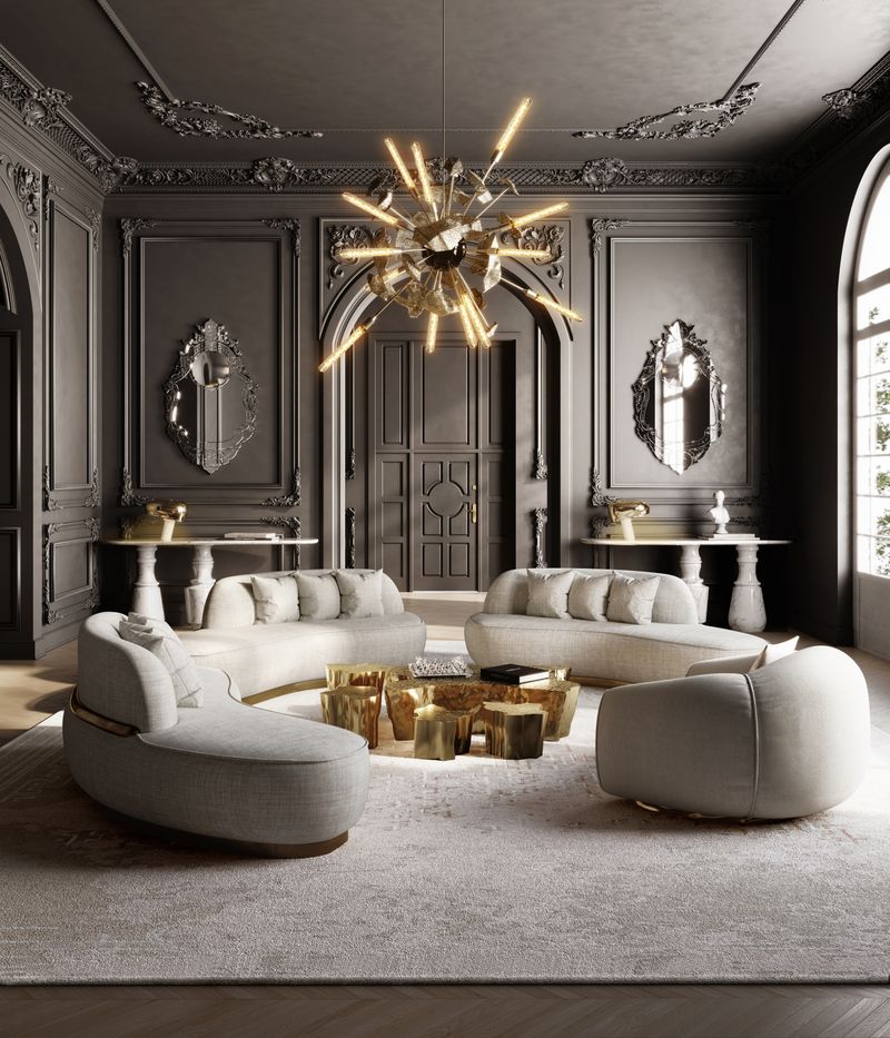 Dark grey living room with curved cream sofas and a swivel chair arranged around a sculptural gold coffee table, beneath a gold starburst chandelier in an ornate paneled interior, luxury design.