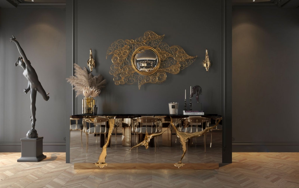 Convex mirror with cloud-shaped gold filigree frame above a sculpted brass console in a grey dining room with a ballerina statue-luxury mirrors.