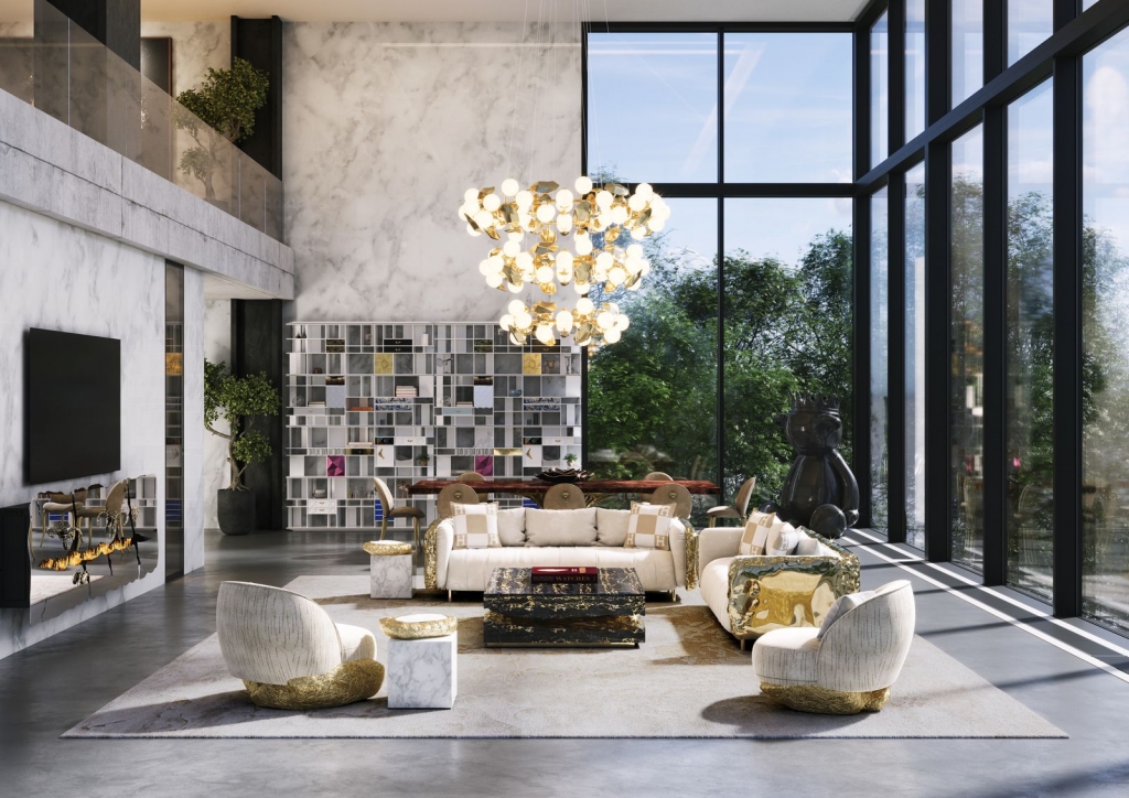Modern loft-style living room with cream sofas, gold-accented armchairs, a marble coffee table, and a cascading gold and white bubble chandelier beneath a double-height marble wall, luxury design.