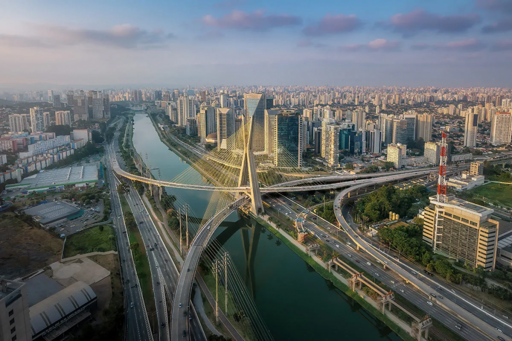 Top real state in São Paulo, Aerial view of São Paulo featuring the iconic Octávio Frias de Oliveira Cable-Stayed Bridge, modern high-rise buildings, wide avenues, and the city's expansive skyline.