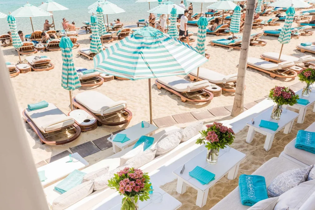 Turquoise umbrellas and white sun loungers at an exclusive beach club -luxury beach clubs in Europe