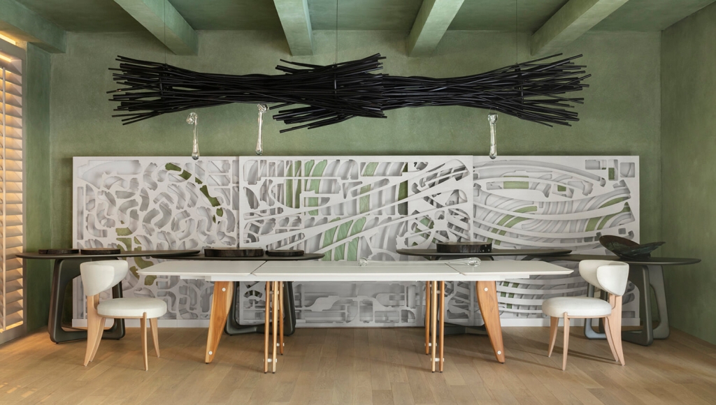 Dining space with a long white table, sculptural black light fixture, and carved decorative wall panels -top showrooms in São Paulo