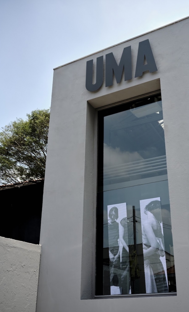 Exterior close-up of the UMA showroom entrance sign and glass door with figure imagery -top showrooms in São Paulo