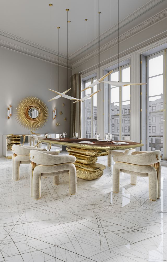 Oval wood table with sculptural molten gold rock-like base beneath angular white chandeliers -luxury dining table