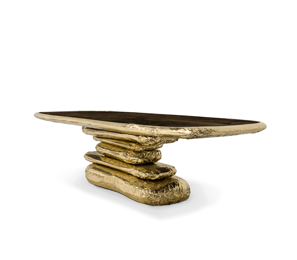Oval table with dark wood top and sculptural stacked gold rock base, studio shot -luxury dining table