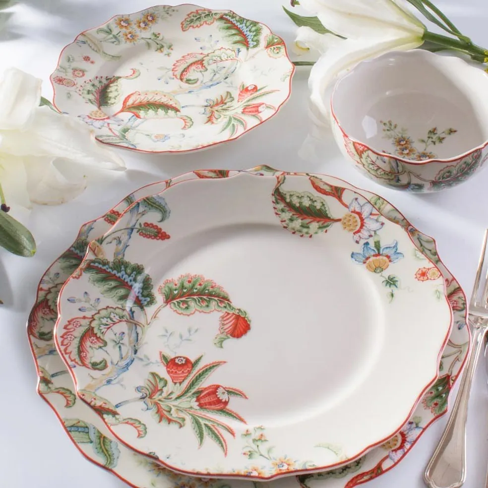 Conjunto de louça de porcelana Tania Bulhões com delicadas estampas florais e bordas onduladas.