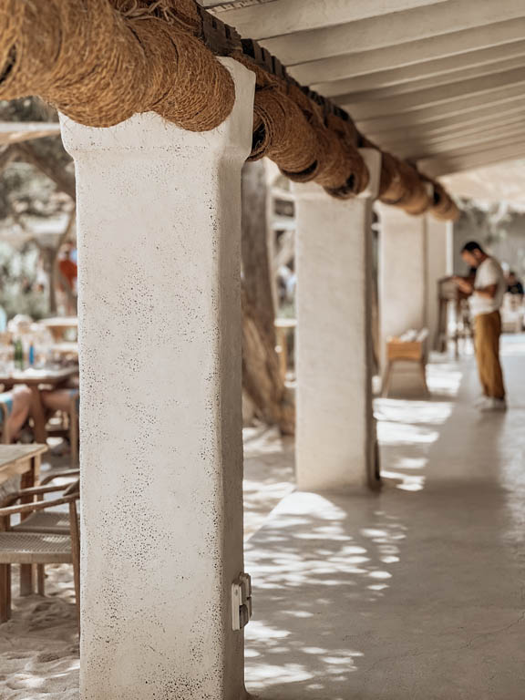 White stucco columns with a rope-wrapped beam on a beach club terrace -luxury beach clubs in Europe