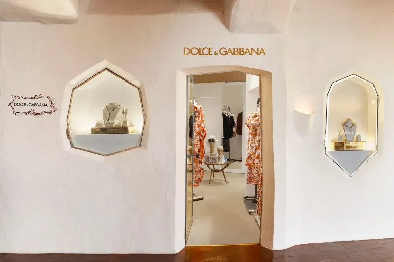 Dolce & Gabbana boutique entrance with a whitewashed facade and clothing displayed inside