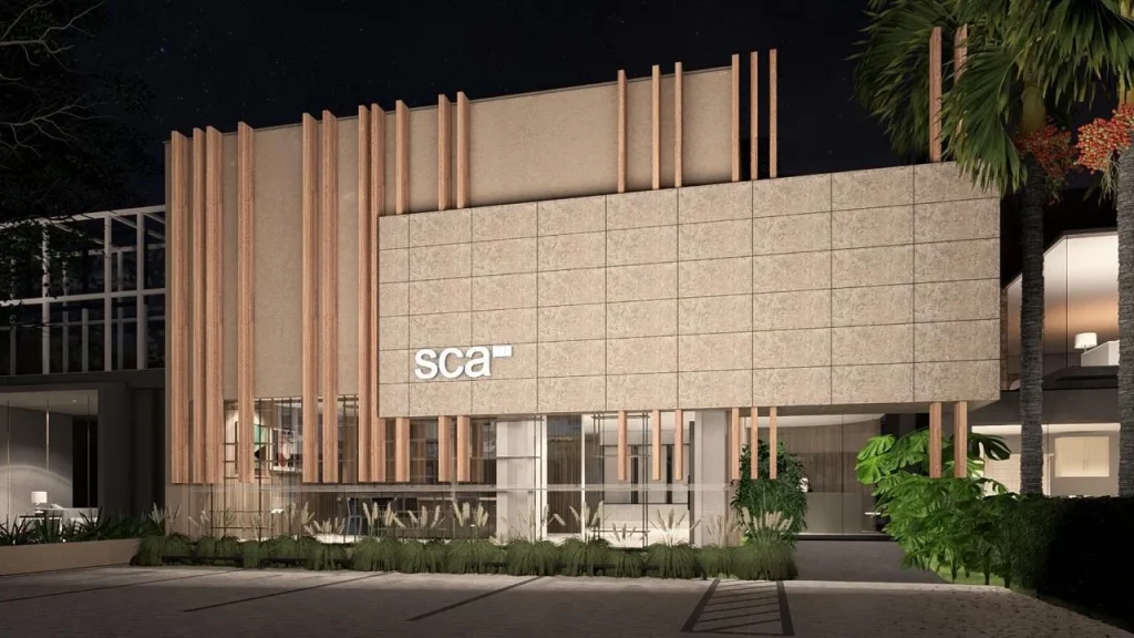 Nighttime exterior of the SCA showroom building with vertical wood slat facade and tropical landscaping -top showrooms in São Paulo