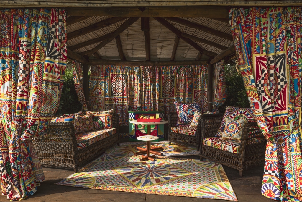 Colorful gazebo lounge decorated with vibrant Dolce & Gabbana Carretto-print fabrics on cushions, curtains, and a rug