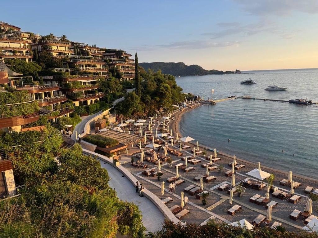 Aerial view of a luxury clifftop resort with private beach and yachts offshore -luxury beach clubs in Europe