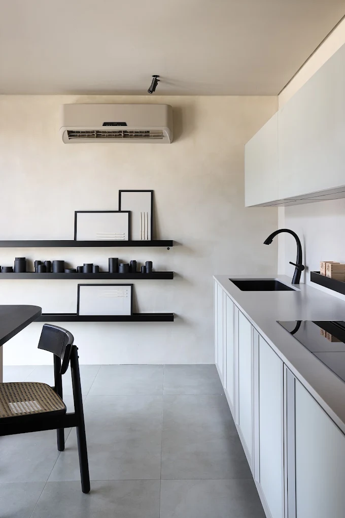 Minimalist kitchen with white cabinetry, black fixtures, and floating black display shelves -top showrooms in São Paulo
