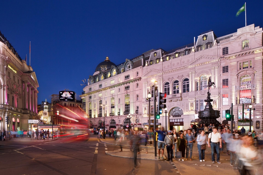 Piccadilly Circus illuminated at night with crowds and traffic in London -best places to live