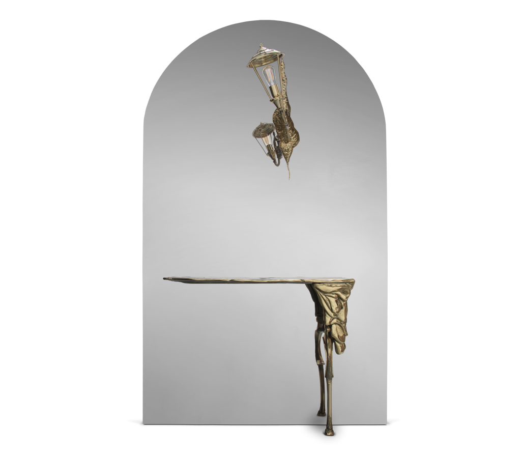 Gold bronze console table and wall lamp with a fluid sculptural design, against a mirrored arched background -top places to live in São Paulo