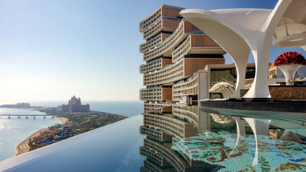 Rooftop infinity pool with decorative mosaics overlooking Atlantis The Royal and the Dubai coastline.