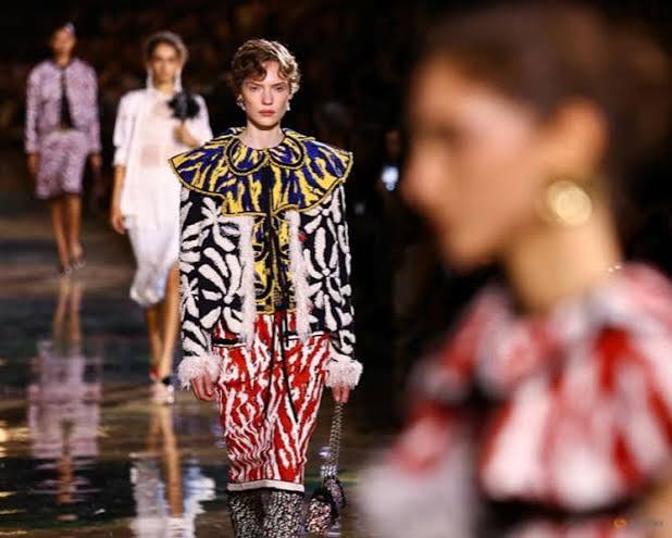 A model walking the runway in a patterned black, white, and yellow jacket with a red-and-white patterned skirt at Paris Fashion Week 2026
